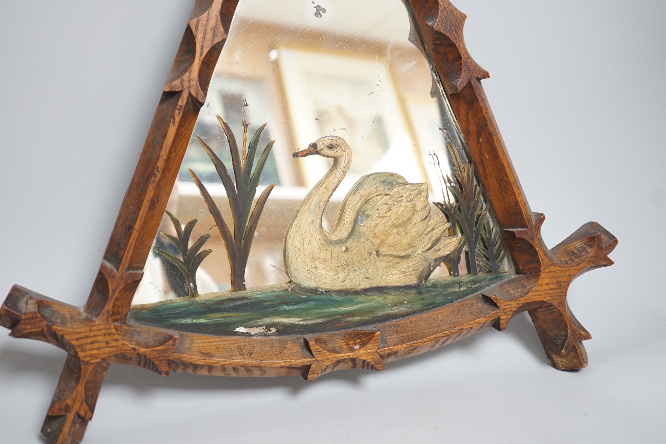 A reformed Gothic oak framed ‘swan’ painted mirror, 55cm tall